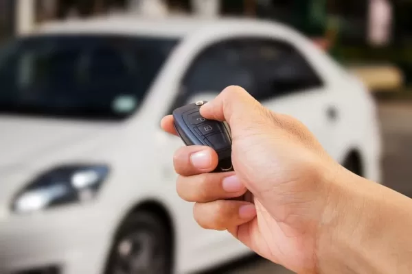 Close-up-hand-holding-car-key-car-alarm